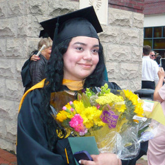 Biany Cruz wearing a cap and gown and holding flowers